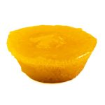 Mini lemon tart with glossy yellow filling on a white background