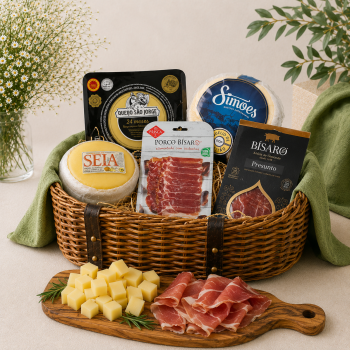 Gift basket of cheeses, cured meats, and packaged goods arranged in a wicker basket for a gourmet spread