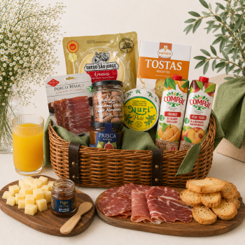 Gift hamper with cheeses, cured meats, crackers, juice boxes, and jars arranged in a wicker basket.
