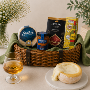 Gourmet gift basket with cheese, jam, cured meat, and a boxed liqueur, plus a Beirão glass nearby.