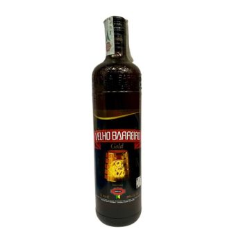 Bottle of Velho Barreiro Gold cachaça with red label and wooden barrel graphic on the front.