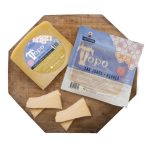 Two wedges of cheese on a wooden cutting board, with blue and yellow labeled packages reading 'Topo' (São Jorge, Açores).